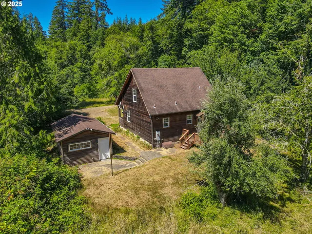a view of a house with a yard and large tree