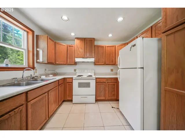 a kitchen with a sink a refrigerator and window