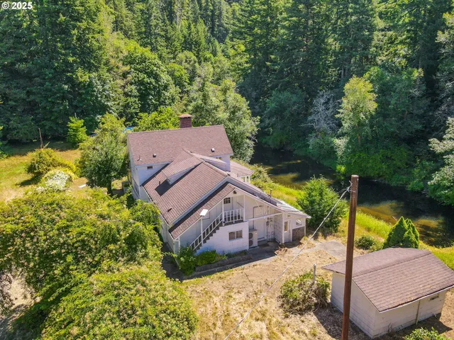 an aerial view of a house with a big yard and large trees