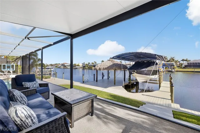 a living room with furniture a flat screen tv and a floor to ceiling window