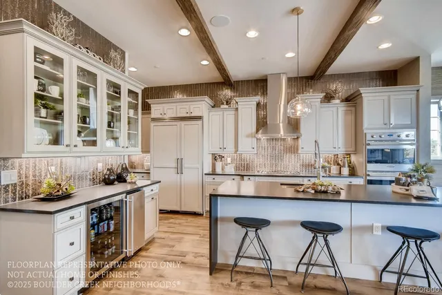 a kitchen with stainless steel appliances kitchen island granite countertop a table chairs in it and wooden floors