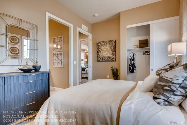 a bedroom with a bed and a lamp on dresser