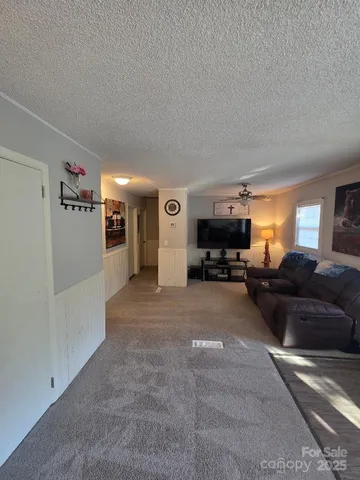 a living room with furniture a ceiling fan and a window