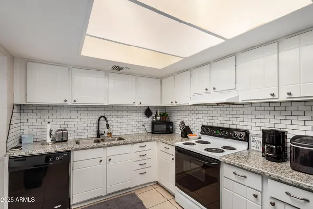 a kitchen with cabinets appliances a sink and a counter top