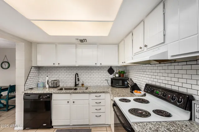 a kitchen with a stove a sink and cabinets
