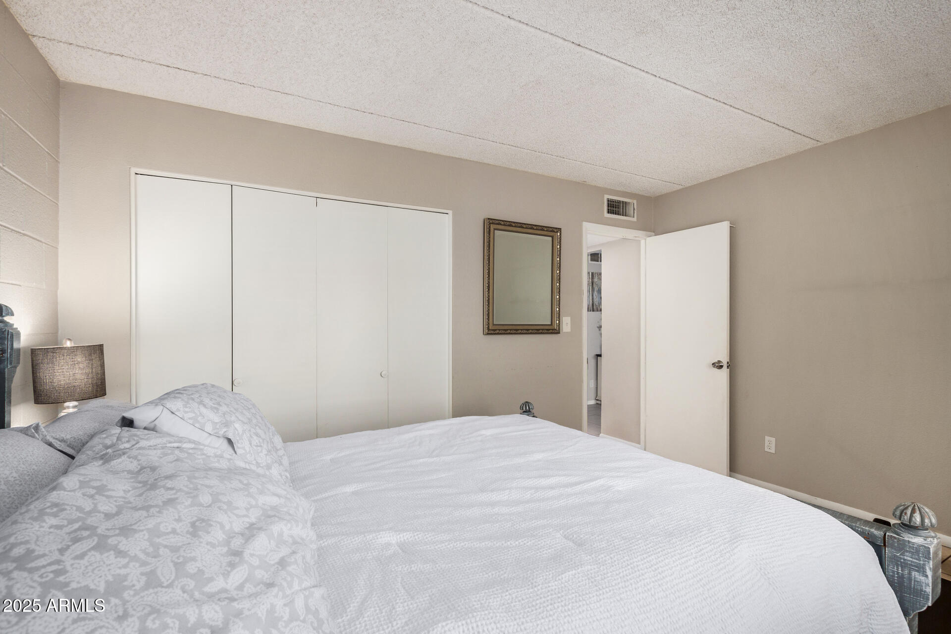 4201 East Camelback Road, Unit 15 Phoenix, AZ 85018 - Photo 19 of 32 a bedroom with a large bed and a chandelier