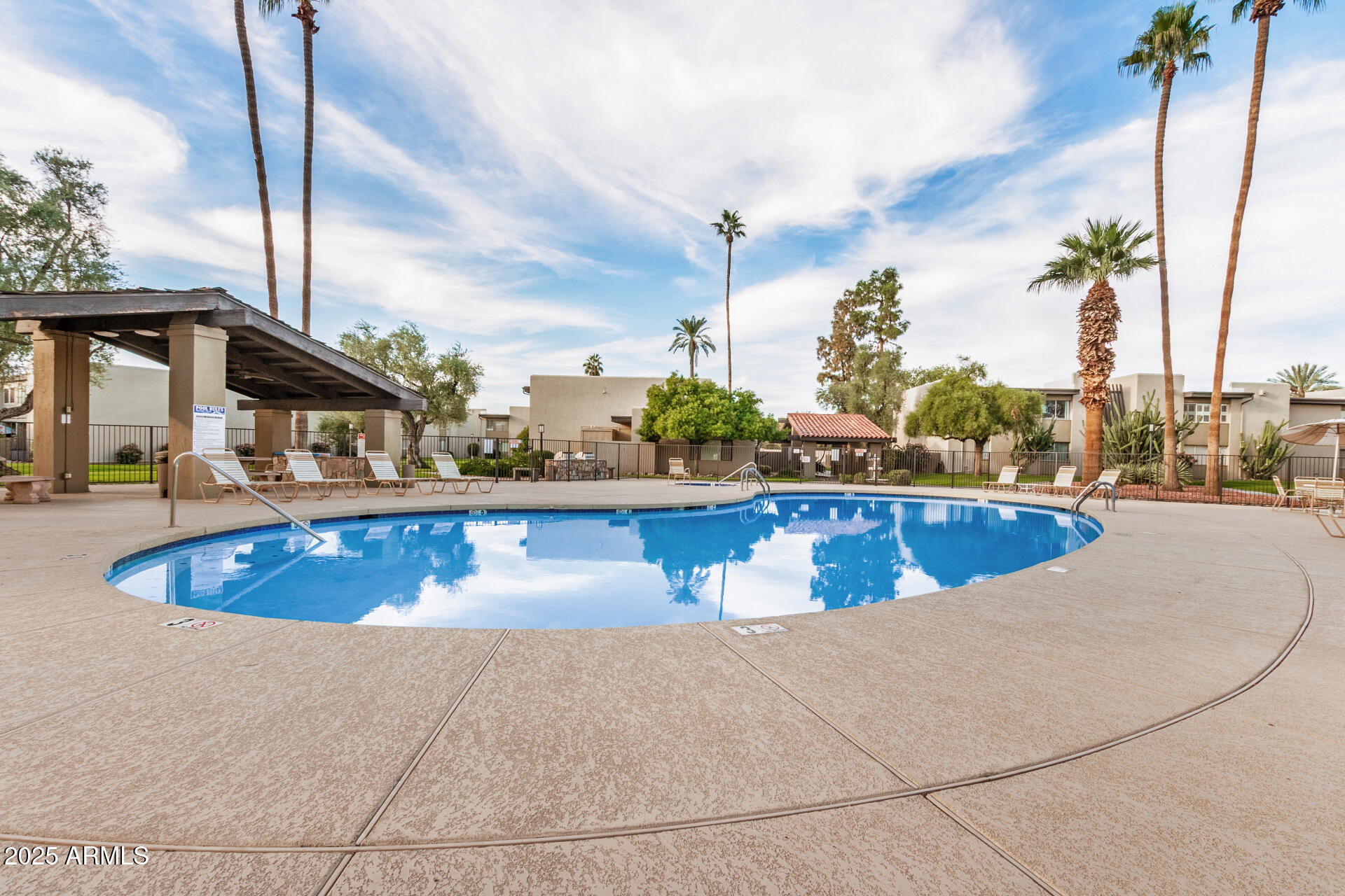 4201 East Camelback Road, Unit 15 Phoenix, AZ 85018 - Photo 31 of 32 a view of a swimming pool with a lawn chairs
