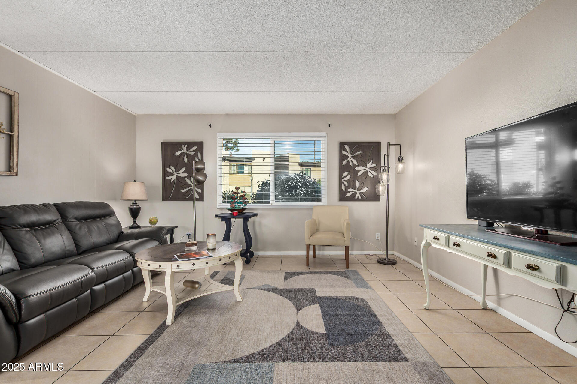 4201 East Camelback Road, Unit 15 Phoenix, AZ 85018 - Photo 5 of 32 a living room with furniture and a flat screen tv