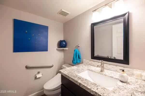 a bathroom with a sink a toilet and a large mirror