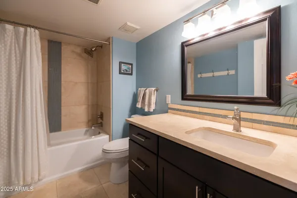 a bedroom with a bed and a flat tv screen on dresser