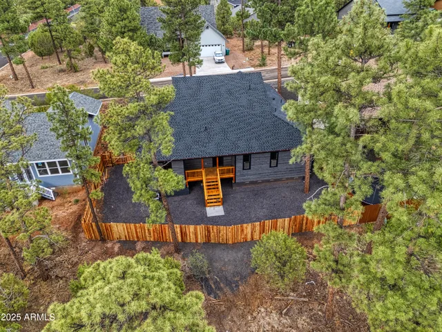 a view of house with outdoor space and trees in the background