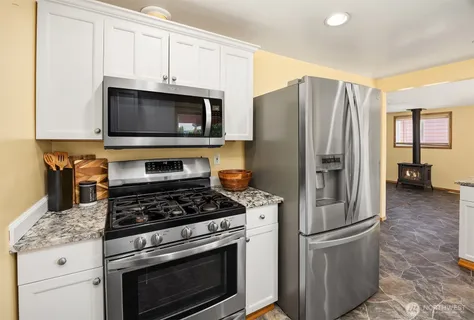 a kitchen with appliances a refrigerator and cabinets