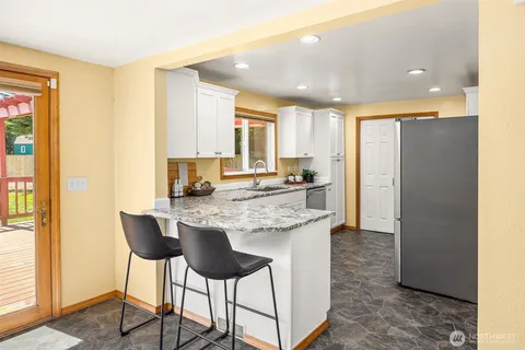 a kitchen with granite countertop a counter space and a refrigerator