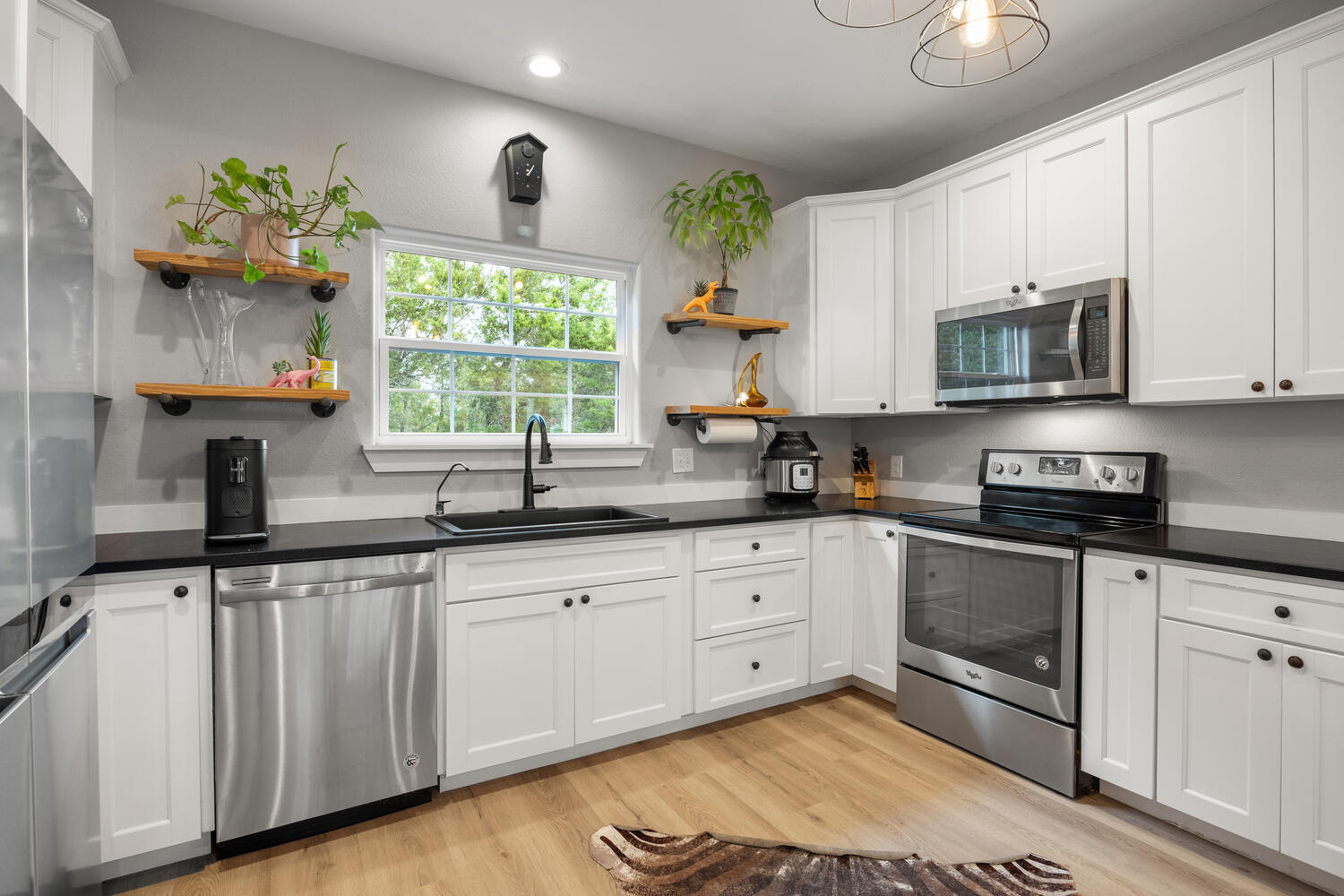 8 Butterfly Street Wimberley, TX 78676 - Photo 7 of 27 Kitchen featuring stainless steel appliances, open shelves, white cabinetry, light wood-style floors, and recessed lighting