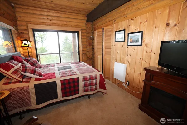 a bedroom with a bed and a flat tv screen