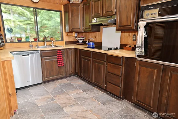 a kitchen with stainless steel appliances granite countertop a sink stove and cabinets