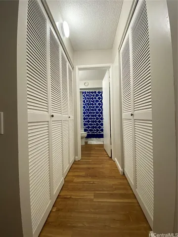 a view of a hallway with wooden floor and windows