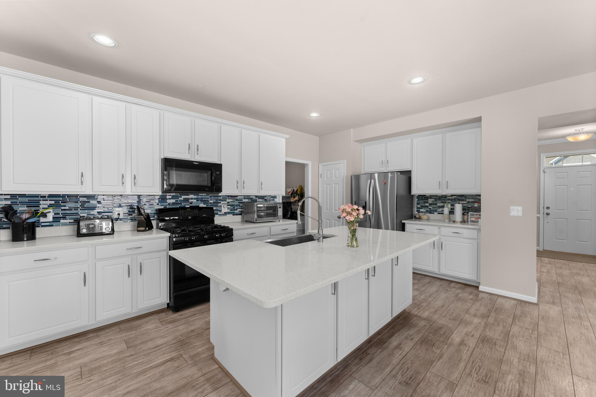10541 Blazing Star Loop Bristow, VA 20136 - Photo 9 of 41 a kitchen with white cabinets appliances and sink