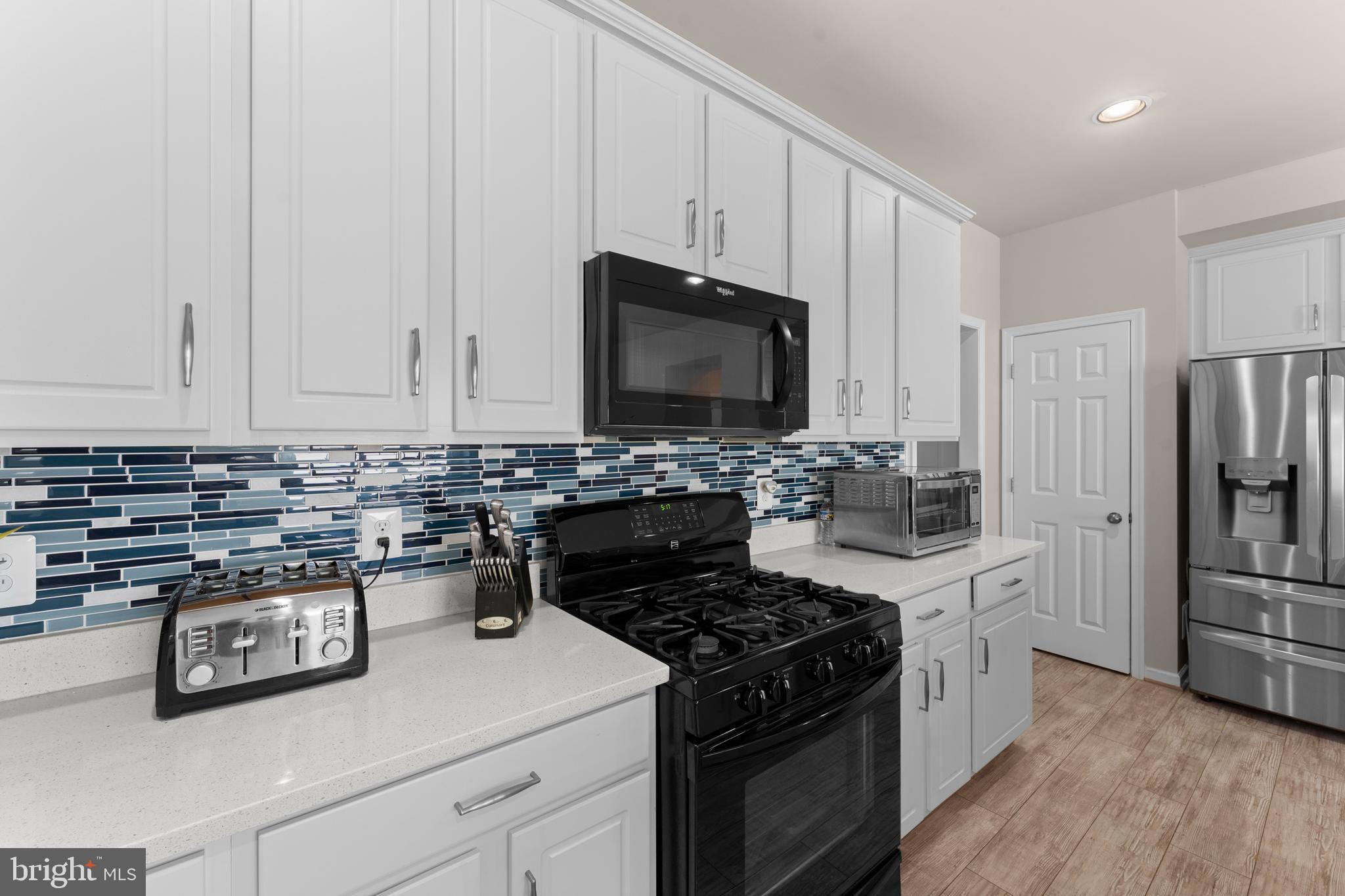 10541 Blazing Star Loop Bristow, VA 20136 - Photo 10 of 41 a kitchen with stainless steel appliances granite countertop a stove a refrigerator and a microwave