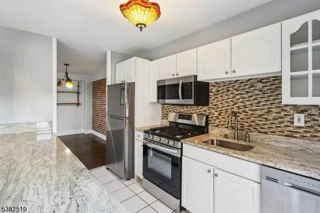 a kitchen with stainless steel appliances a stove a sink a microwave and cabinets