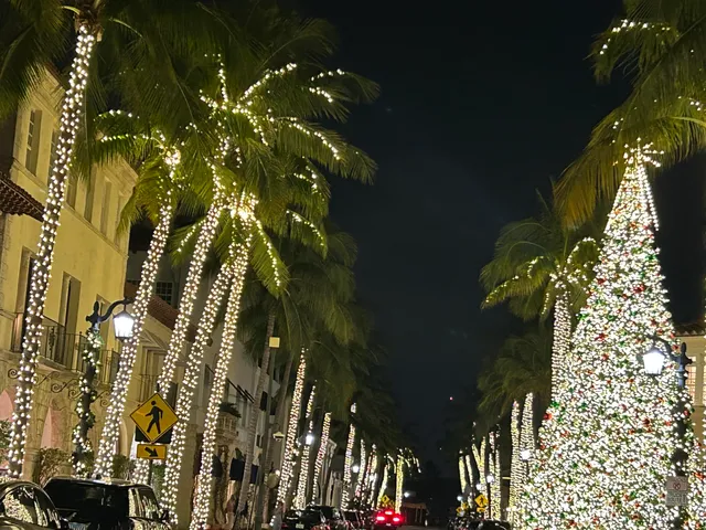 a large white kitchen with kitchen island a stove a sink a refrigerator and white cabinets with wooden floor