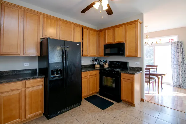 a kitchen with granite countertop a refrigerator and a stove top oven