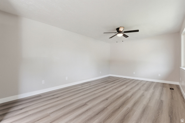 629 King Circle Layton, UT 84041 - Photo 8 of 26 Spacious room featuring light gray walls, wood-finish flooring, white baseboards, and a ceiling fan with integrated lighting