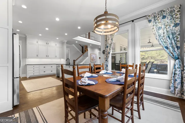 a view of a dining room with furniture a chandelier and wooden floor