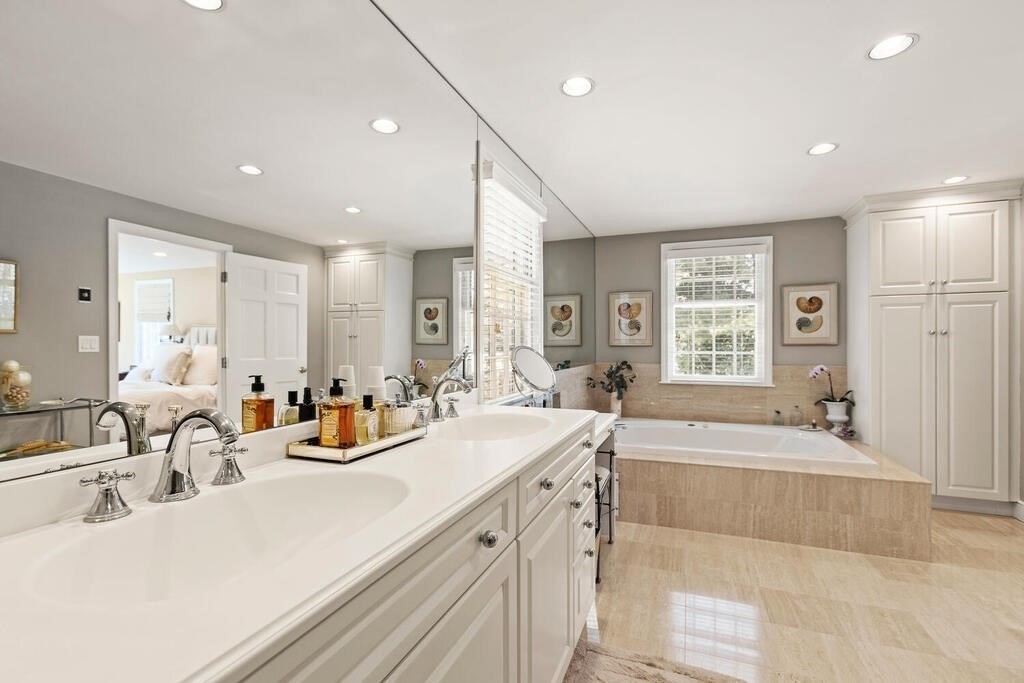 70 Windsor Road Needham, MA 02492 - Photo 19 of 35 a large bathroom with double vanity sinks a large mirror and a bathtub