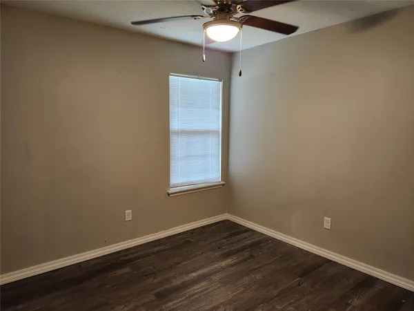an empty room with a window and wooden floor