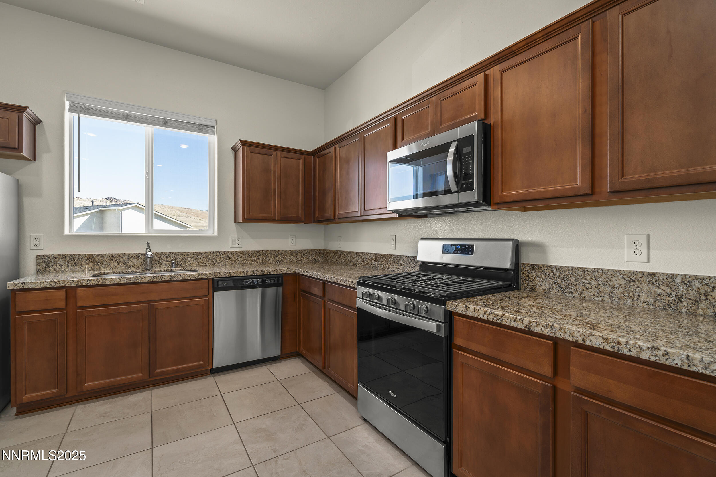 5013 Cavestone Road Sun Valley, NV 89433 - Photo 12 of 21 a kitchen with stainless steel appliances granite countertop wooden cabinets a stove top oven a sink and dishwasher