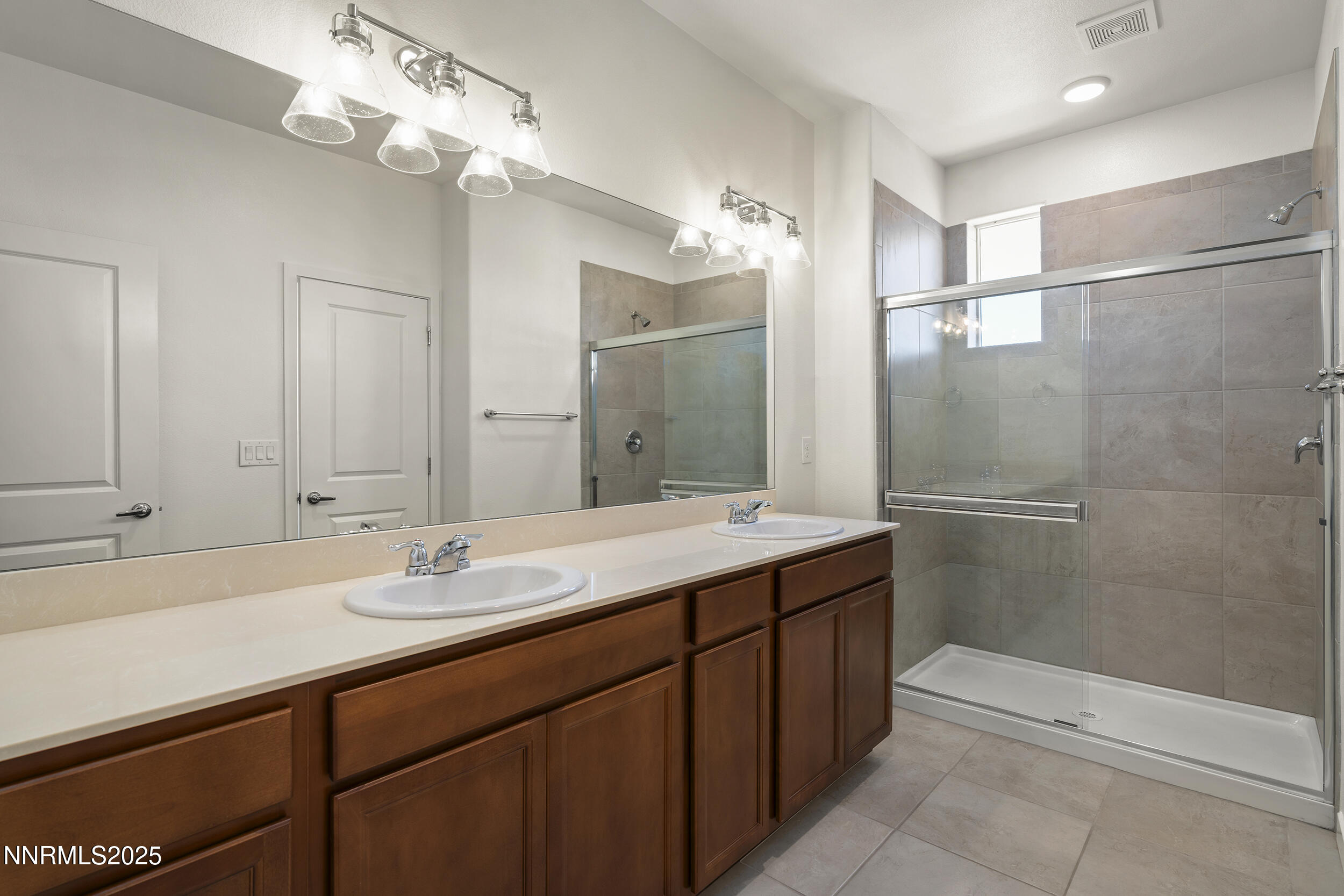 5013 Cavestone Road Sun Valley, NV 89433 - Photo 18 of 21 a bathroom with a double vanity sink mirror and shower