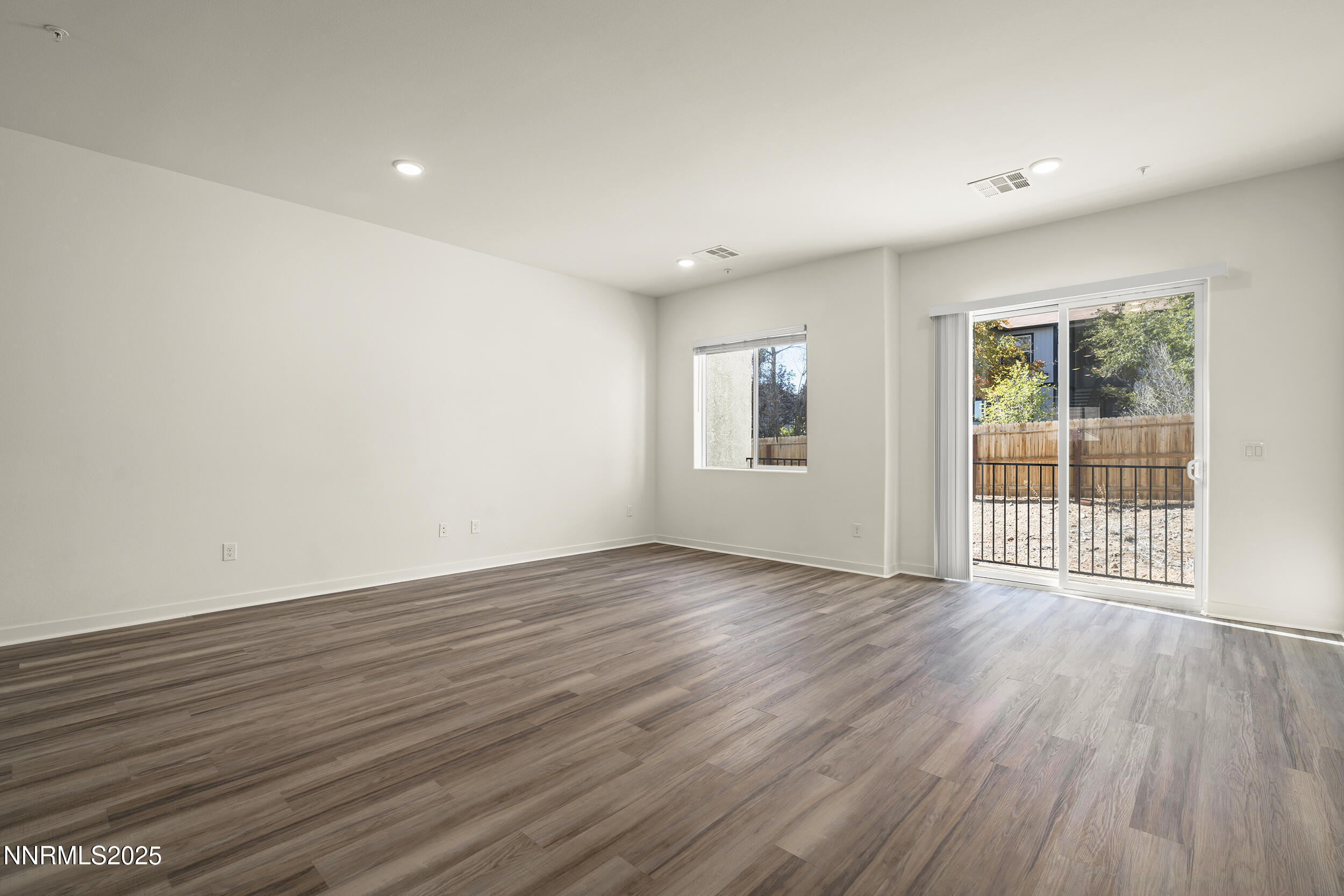 5013 Cavestone Road Sun Valley, NV 89433 - Photo 3 of 21 a view of an empty room with wooden floor and a window
