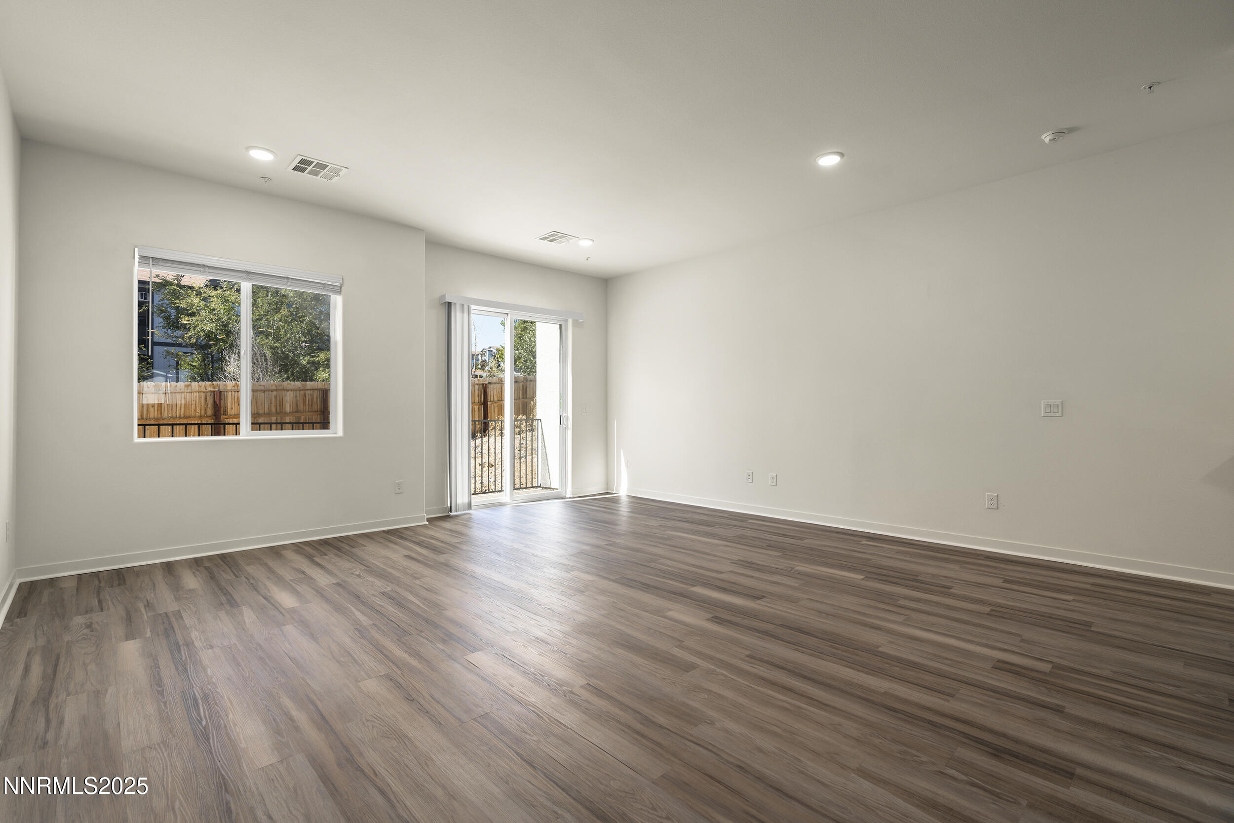 5013 Cavestone Road Sun Valley, NV 89433 - Photo 6 of 21 a view of an empty room with wooden floor and a window