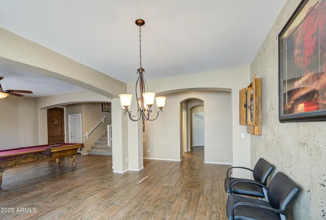 a view of a dining room with furniture and a chandelier fan