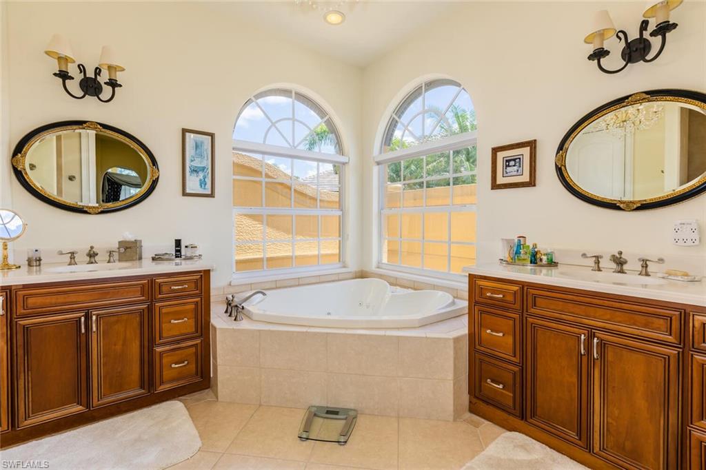 7025 Kiwi Place Naples, FL 34113 - Photo 12 of 28 a bathroom with a double vanity sink and a mirror