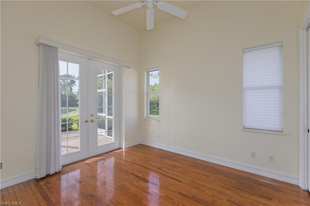 7025 Kiwi Place Naples, FL 34113 - Photo 17 of 28 an empty room with wooden floor and windows