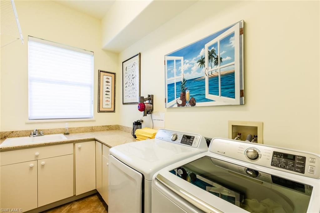 7025 Kiwi Place Naples, FL 34113 - Photo 18 of 28 a utility room with cabinets washer and dryer