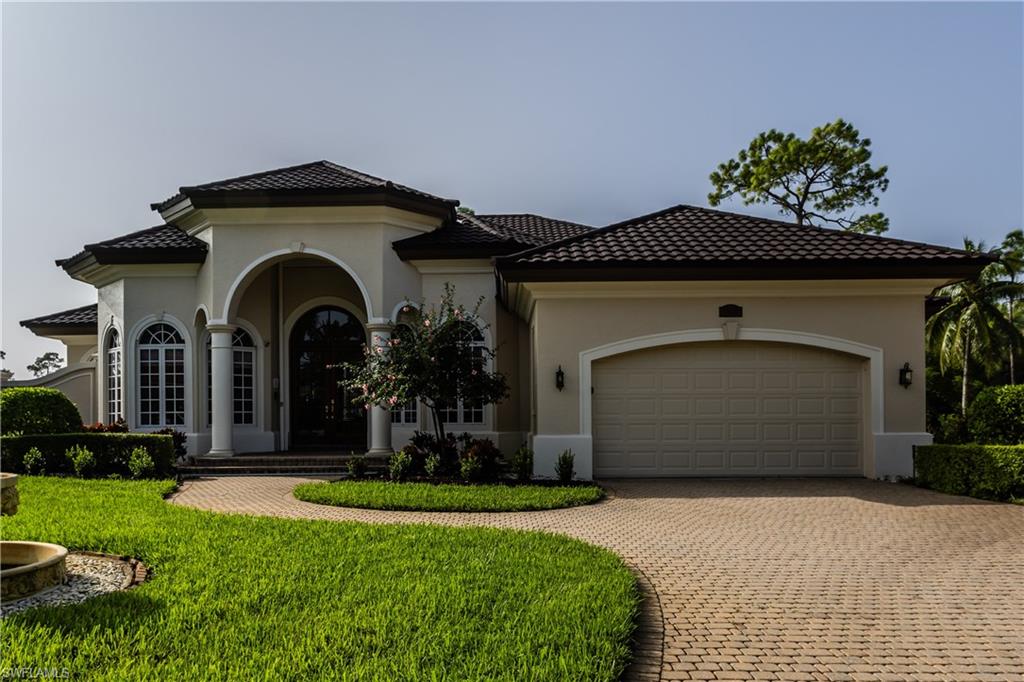 7025 Kiwi Place Naples, FL 34113 - Photo 2 of 28 a front view of a house with a yard