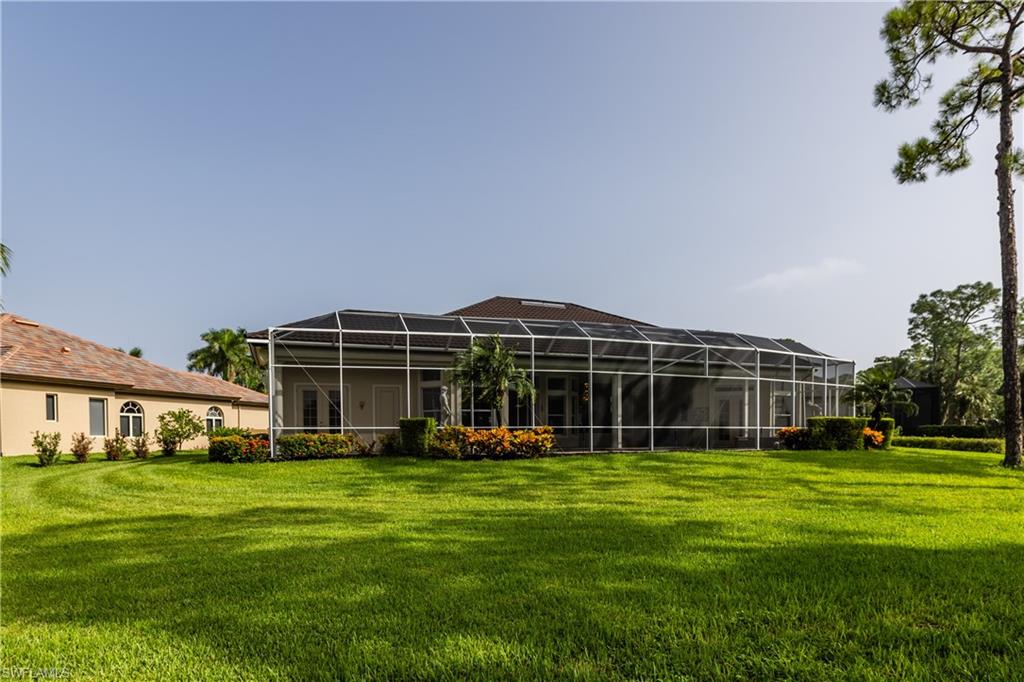7025 Kiwi Place Naples, FL 34113 - Photo 26 of 28 a view of a house with a big yard and large trees