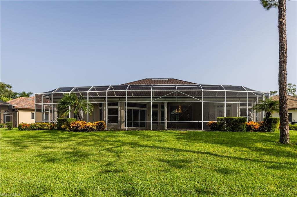 7025 Kiwi Place Naples, FL 34113 - Photo 27 of 28 a view of a house with a big yard and large trees