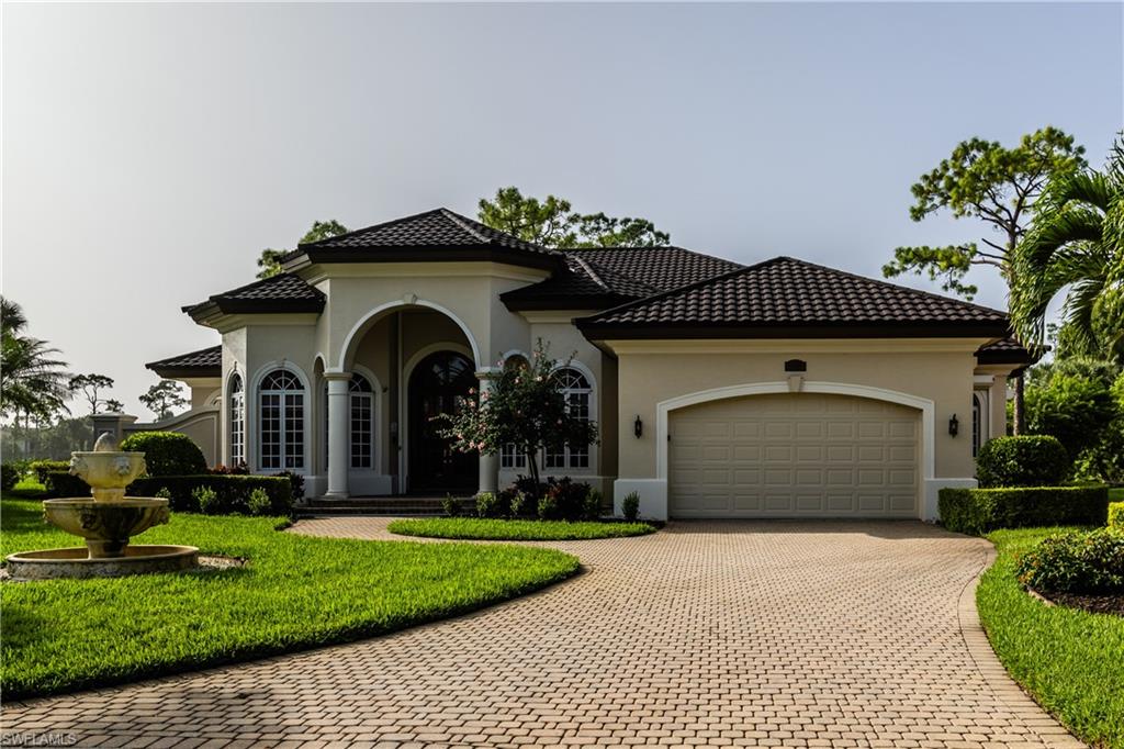 7025 Kiwi Place Naples, FL 34113 - Photo 3 of 28 a front view of a house with garden