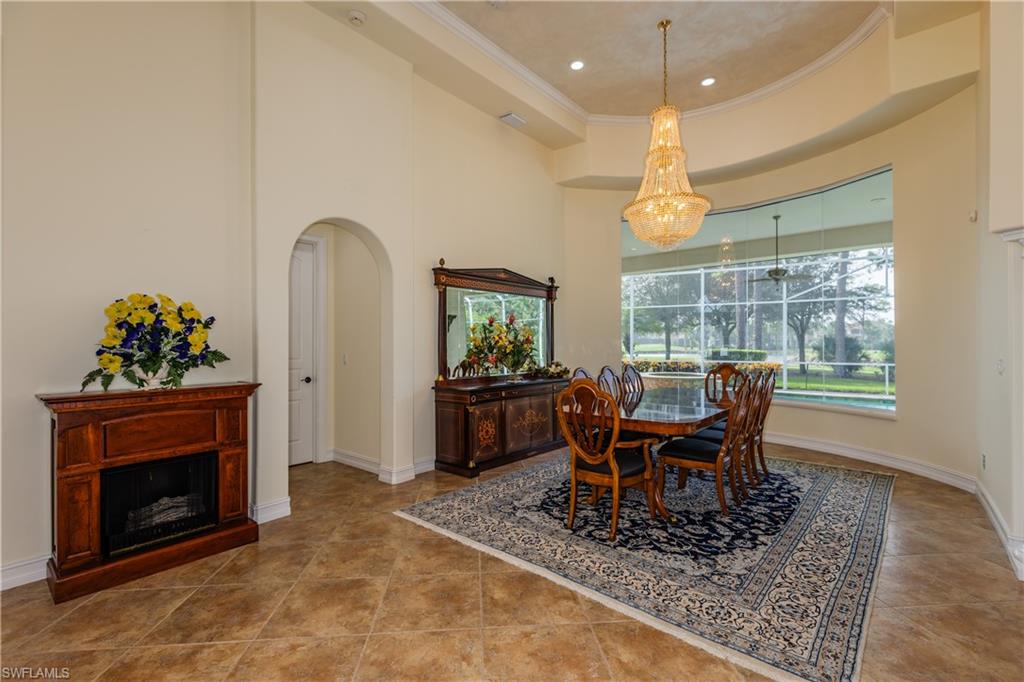 7025 Kiwi Place Naples, FL 34113 - Photo 5 of 28 a dining room with furniture a floor to ceiling window and a fireplace