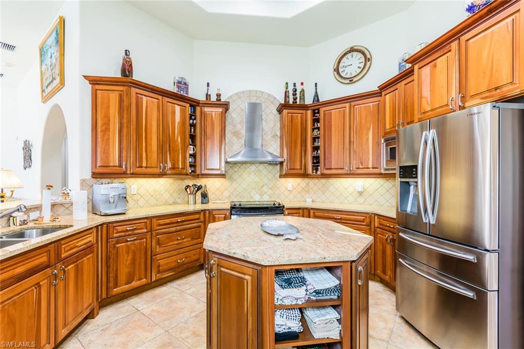 7025 Kiwi Place Naples, FL 34113 - Photo 10 of 28 a kitchen with a sink a refrigerator and cabinets