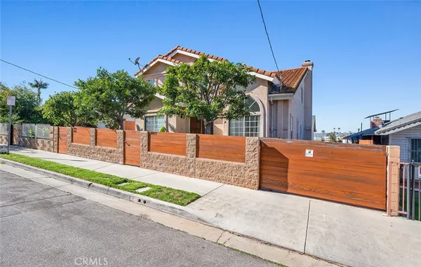 a view of a house with a yard and potted plants