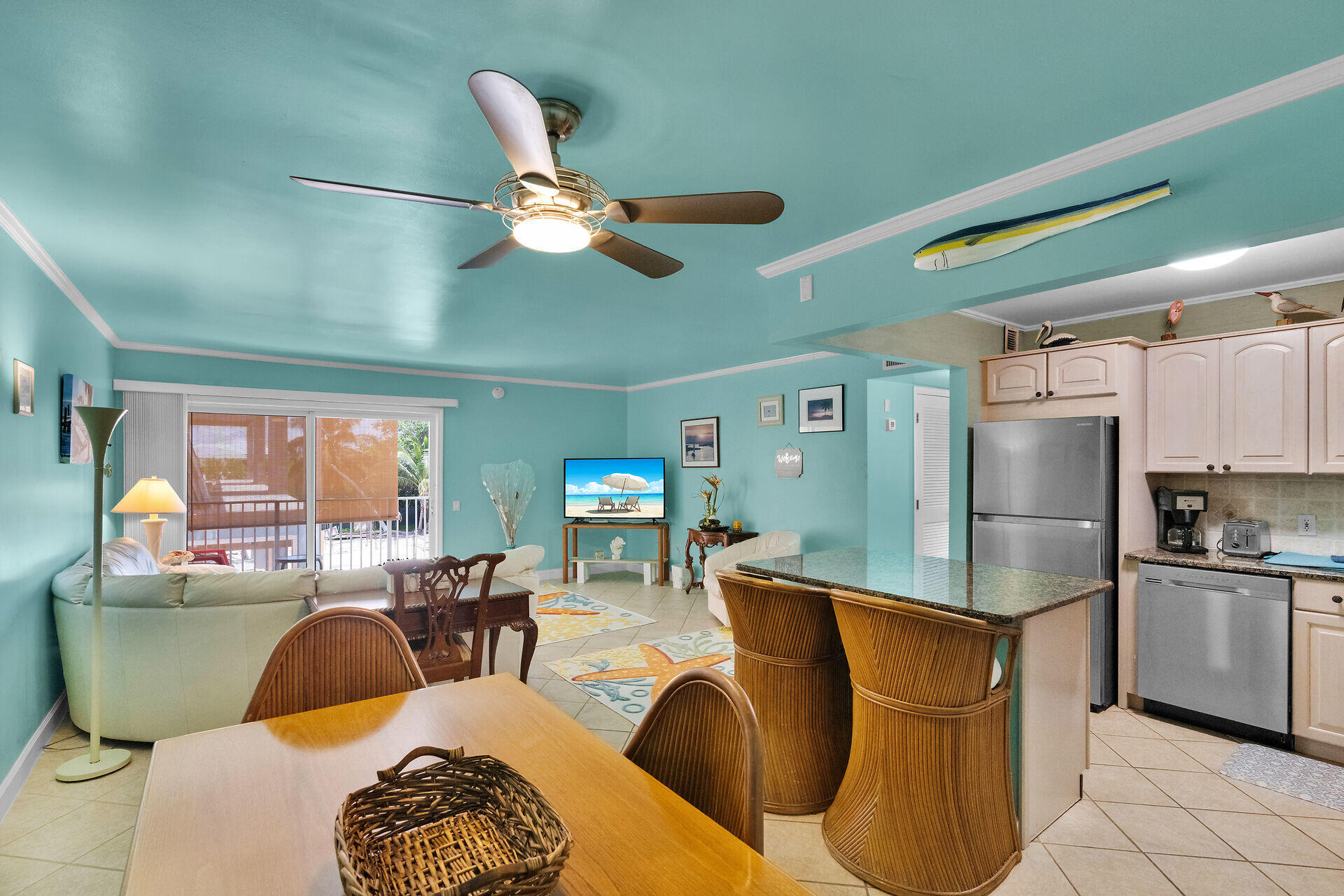 a living room with stainless steel appliances furniture and a large window