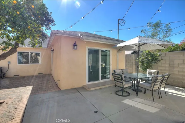 a view of a patio with table and chairs under an umbrella
