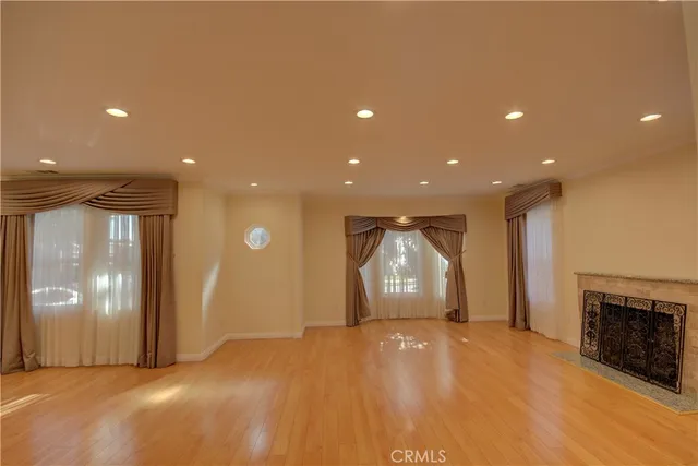a view of empty room with wooden floor and fireplace