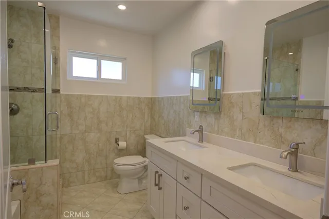 a bathroom with a double vanity sink toilet and shower