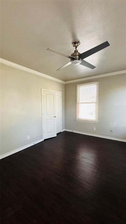 4511 Junius Street Dallas, TX 75246 - Photo 4 of 16 Spacious bedroom room featuring dark wood-flooring, light-toned walls, and white crown molding